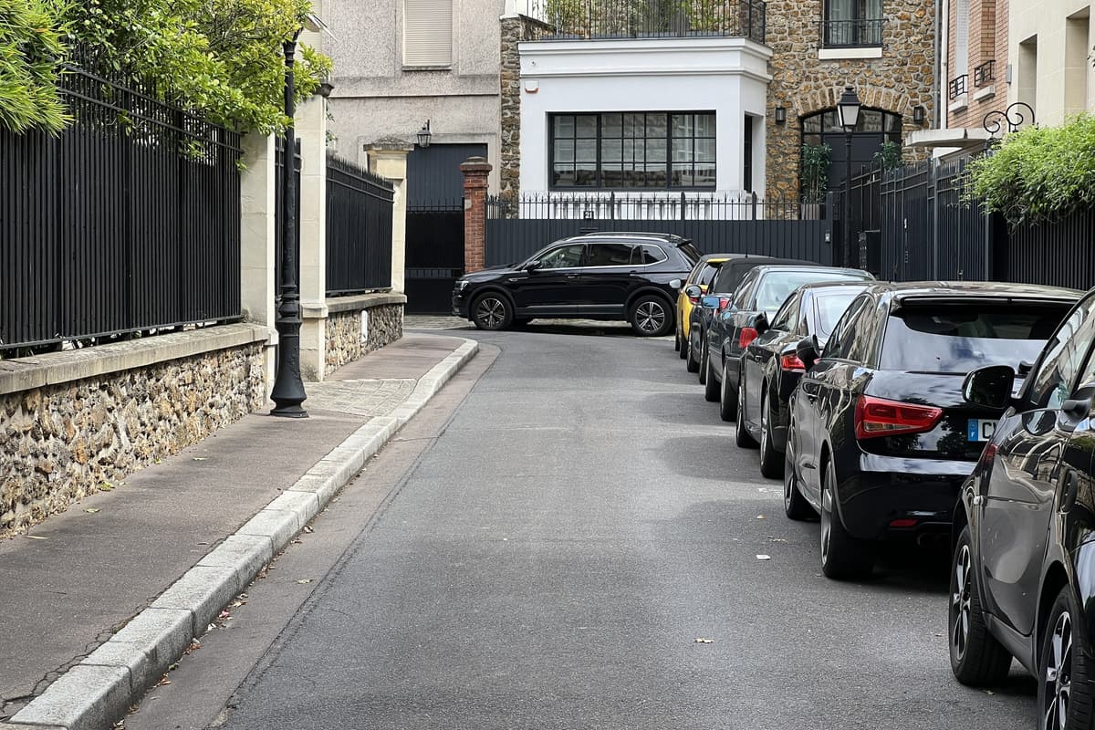 L'avenue Perronet, voie privée bordée de murs de pierre et de grilles, des maisons au fond.