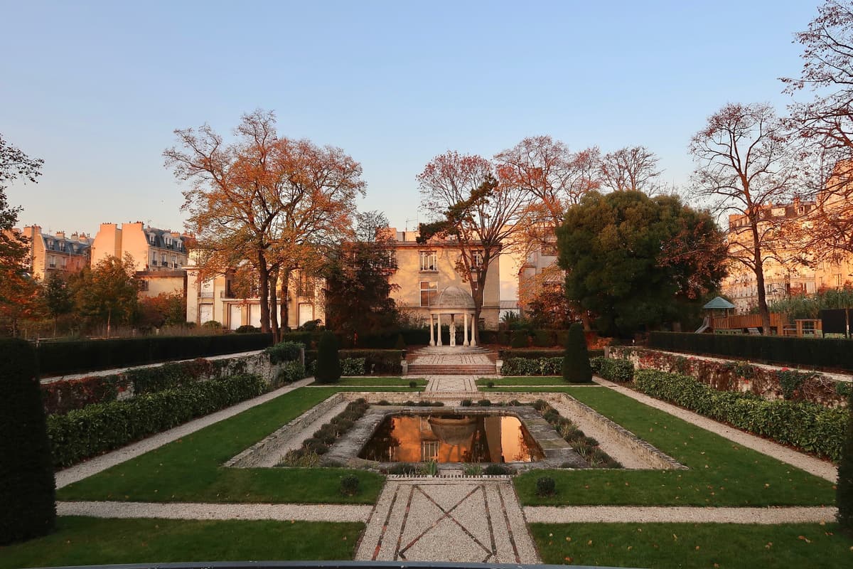 Parc de la Folie Saint-James à l'automne : un bassin entre des pelouses, une petite rotonde au fond, des immeubles derrière les arbres.